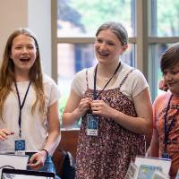 four students posing for a photo behind their exhibit at student project showcase